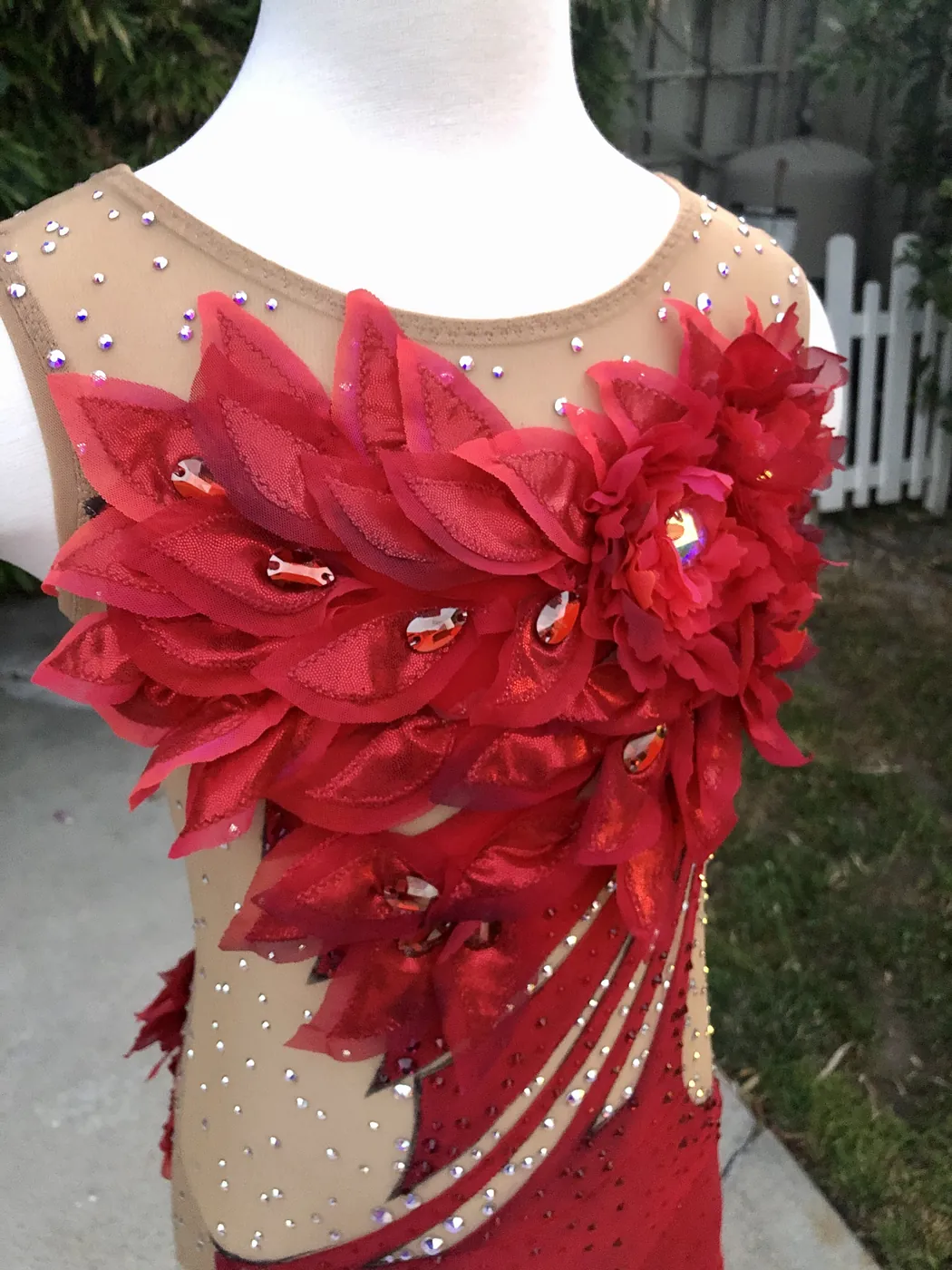 Red competition leotard with a cascade of hand-cut petals down the bodice and crystals scattered across the mesh.